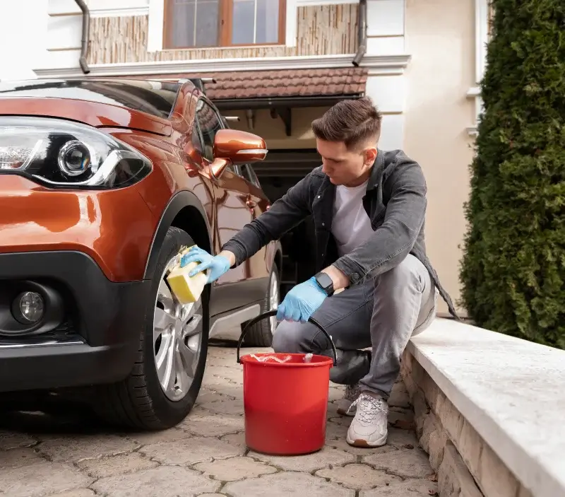 Lavage auto à domicile Gironcourt-sur-Vraine : professionnel intervenant sur un véhicule